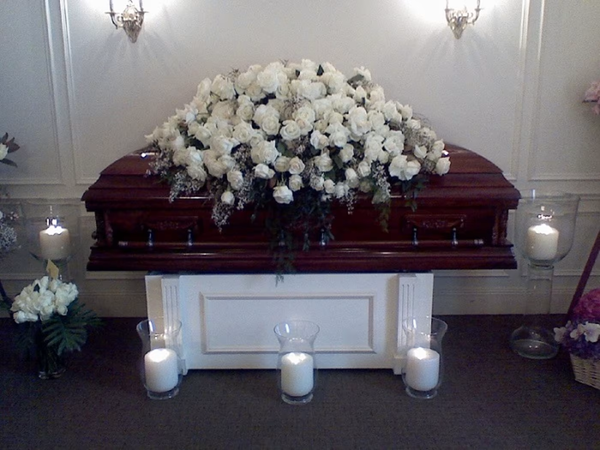 White Casket Spray funeral floral arrangement, a serene and dignified tribute featuring white blooms, perfect for memorial services and honoring loved ones, available for same-day delivery in Los Angeles.