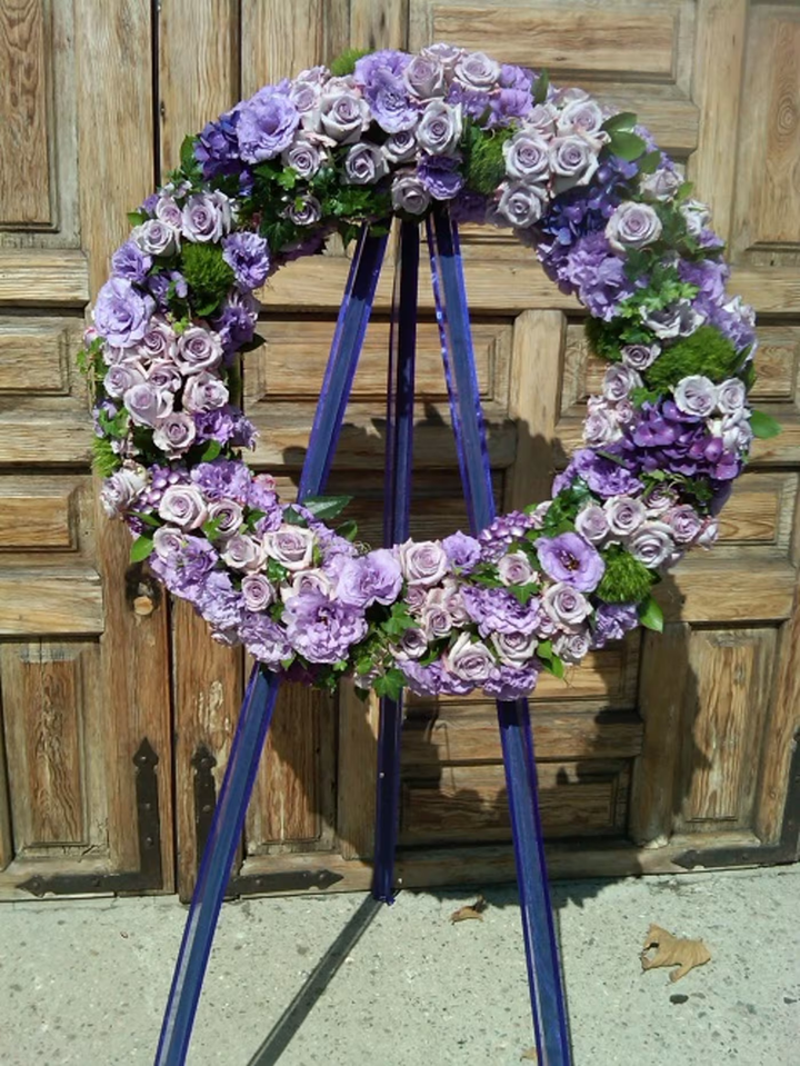 Purple Wreath funeral floral arrangement, a dignified tribute featuring purple and lavender blooms, ideal for memorials and funerals, available for same-day delivery in Los Angeles.